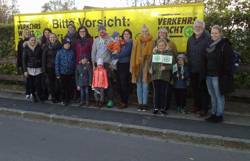 „Bitte Vorsicht – Kindergartenkinder!“ mahnt ein am Zaun des St. Wolfgang-Kindergartens angebrachtes Transparent, das an die Autofahrer appelliert, den Fuß vom Gas zu nehmen. V. r.: Magdalena Wölker (KiTa), Hubert Ritz Verkehrswachtvors.), Uta-Maria Kriegler (KiTa-Leiterin), Michaela Meier (EB), Sandra Uhl (EB), Uwe Schlaffer (Stv.Vors. EB), Christine Graf (EB), Eva Ries (Vors. EB), Laura Rustler, Selina Dalitz, Julia Waldhauser (alle KiTa) und Isabel Tröster (EB). - Foto von Werner Schulz