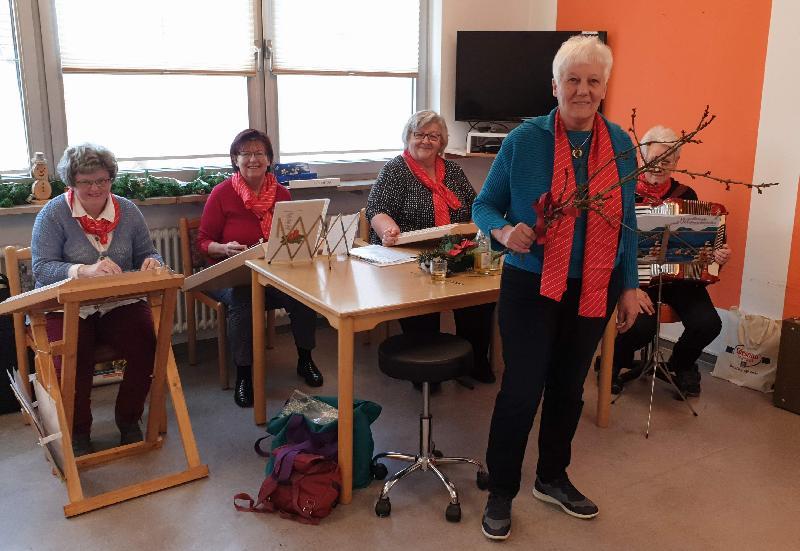 Die Leiterin der Klangbrettgruppe Hildegard Kohl (stehend) hatte Barbarazweige mitgebracht. Sie schilderte die Barbara-Legende und erinnerte daran, dass Barbara zusammen mit Margarete und Katharina zu den „drei heiligen Madln“ zählt - eine Tatsache, die einigen der Senioren sehr wohl bekannt war. Für musikalische Abwechslung sorgten die Klangbrett-Damen mit bekannten Advents- und Weihnachtsliedern. - Foto von Werner Schulz