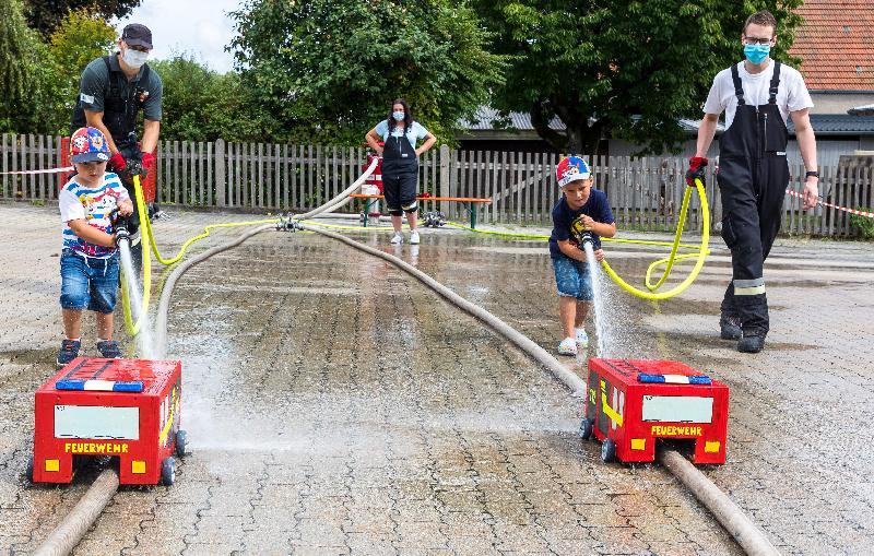 Spannung pur herrschte bei den Spritzenwettrennen, bei denen die hölzernen Feuerwehrautos mit einem Wasserstrahl aus einem B-Schlauch schnellstmöglich über die Ziellinie getrieben werden mussten. - Foto von Werner Schulz