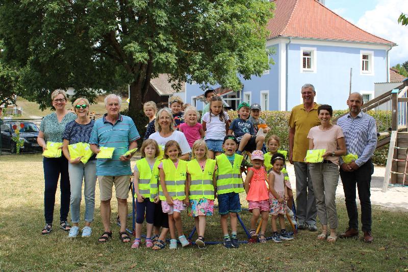 Kinder des St. Wolfgang-Kindergartens, mit ihren neuen Warnschutzwesten, mit v. li. Bettina Rösch, Evelyn Högl, Franz Dorfner, Uta Kriegler, Sepp Falk (FW), Gisela Falk und Stadtrat Matthias Dotzler. - Foto von Fritz Dietl