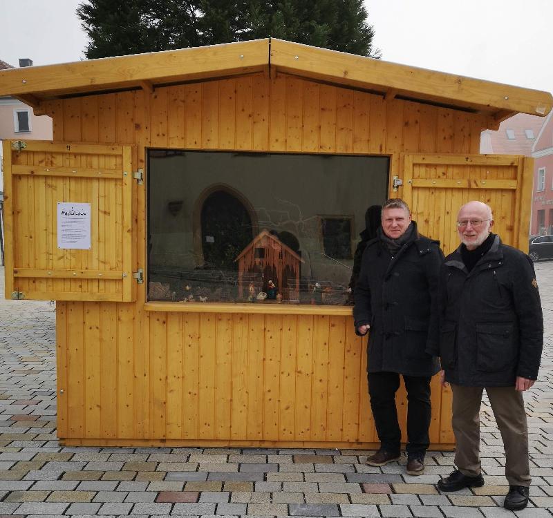 Neben dem Christbaum auf dem Marktplatz ist in einem Marktstand bis zum 6. Januar 2024 täglich von 8 bis 20 Uhr eine von Stadtrat Martin Merkl (2.v.r.) organisierte und von Josef Kohl (r.) bestückte Krippenausstellung zu besichtigen. - Foto von Werner Schulz