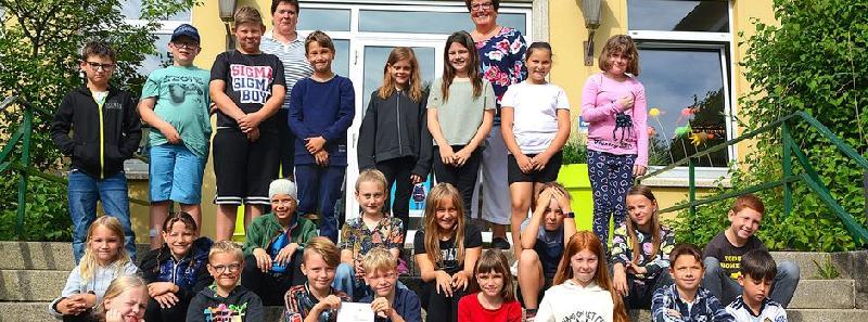 Die Hirschauer Kommunionkinder bei der Spendenübergabe vor der Hirschauer Schule. Li. hinten Gemeindereferentin Barbara Schlosser, re. hinten Karin Borchers von 