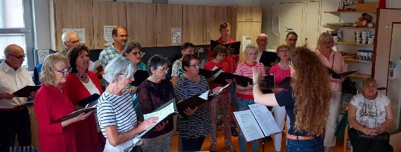 Mit seiner Serenade, die wegen des Wetters vom Garten ins Heim verlegt wurde, bereitete der Gemischte Chor unter Leitung von Jana Müller (am Dirigentenpult) den Bewohnern des BRK Seniorenwohn- und Pflegeheims St. Barbara und den zahlreichen Gästen einen gleichermaßen stimmungsvollen wie kurzweiligen Abend. Ditzend die Vorsitzende Renée Ehringer-Hoffmann. - Foto von Rudi Wild