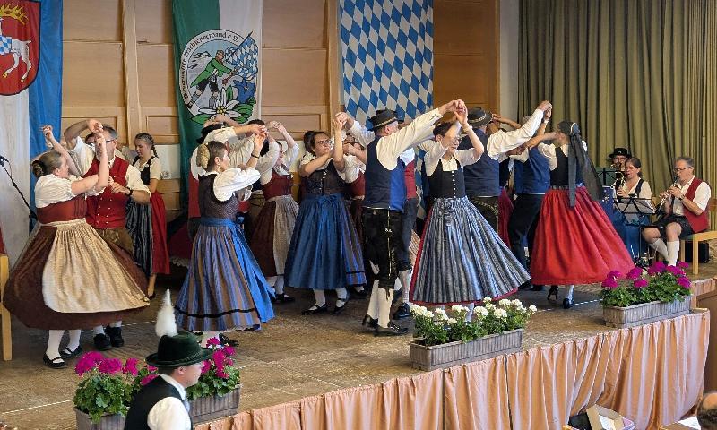 Ein buntes Programm an Tanzdarbietungen boten die Gruppen der einzelnen Trachtenvereine beim Jubiläumsabend im Hirschauer Josefshaus, hier die Gautanzgruppe mit dem Fensterltanz. Bildmitte: Gau-Vortänzer Gaston Lottner, der durch das Programm führte, mit Ehefrau Iris. - Foto von Christian Summer