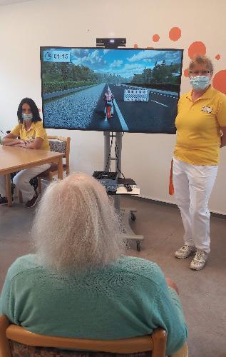 Im Seniorenheim mit dem Motorrad auf der Autobahn unterwegs – dank der MemoreBox ist dies im Seniorenheim St. Barbara möglich. Die „Fahrlehrerinnen“ Doris Schwarzbauer (l.) und Margaretha Lacher (r.) passen auf, dass nichts passiert. - Foto von Werner Schulz